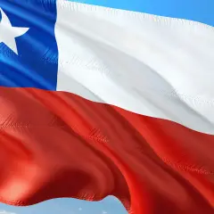 Flaga Chile powiewa na wietrze. Biały pas, czerwony pas i niebieski kwadrat z białą gwiazdą symbolizują ten kraj.