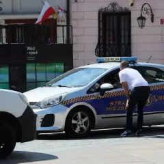 Strażnik miejski rozmawia z kierowcą. Czy łódź jest bezpieczna? Nie, to radiowóz.