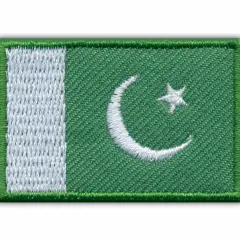 Naszywka z flagą Pakistanu. Zielone tło z białym półksiężycem i gwiazdą, oraz pionowym białym pasem po lewej stronie.
