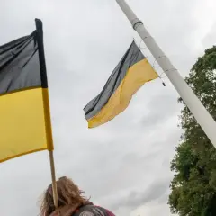 Flaga Kaszub powiewa na maszcie. Dwie flagi w kolorach czarnym i żółtym, symbolizujące Kaszuby, są widoczne na tle pochmurnego nieba.