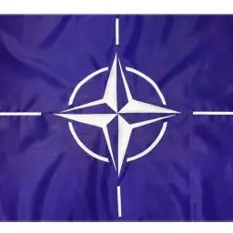 Flaga NATO: granatowe tło, biała czteroramienna gwiazda z okręgiem i czterema białymi liniami.