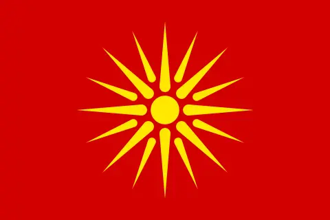Czerwona flaga Macedonii z żółtym słońcem o ośmiu promieniach.