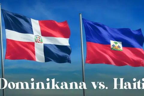 Dwie flagi powiewają na wietrze: dominikana flaga z białym krzyżem i herbem oraz flaga Haiti.