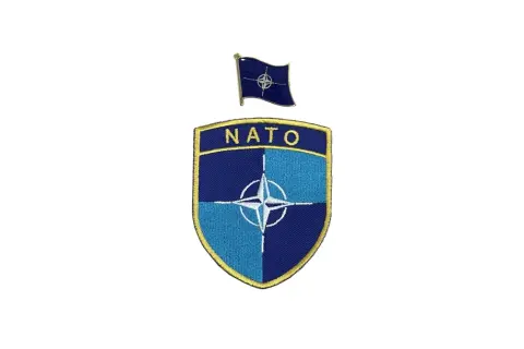 Naszywka i przypinka z symbolem NATO.