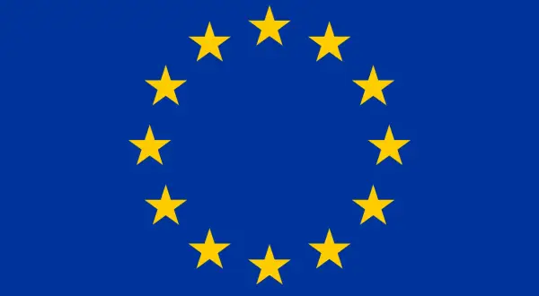 Flagi krajów europejskich tworzą okrąg złotych gwiazd na niebieskim tle. Symbol jedności i współpracy.