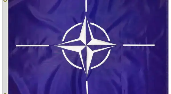 Flaga NATO: granatowe tło, biała czteroramienna gwiazda z okręgiem i czterema białymi liniami.