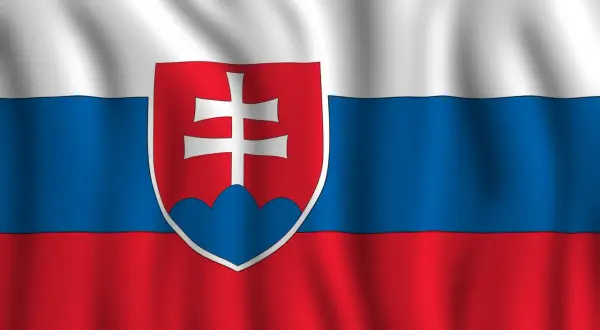 Flaga Słowacji powiewa na wietrze. Biały, niebieski i czerwony pas z herbem Słowacji po lewej stronie.