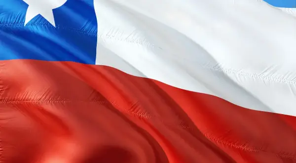 Flaga Chile powiewa na wietrze. Biały pas, czerwony pas i niebieski kwadrat z białą gwiazdą symbolizują ten kraj.