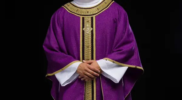 Szata liturgiczna w barwach papieskich, fioletowa z bogatymi złotymi zdobieniami, symbolizująca czas pokuty i refleksji.