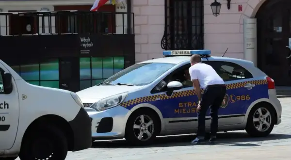 Strażnik miejski rozmawia z kierowcą. Czy łódź jest bezpieczna? Nie, to radiowóz.