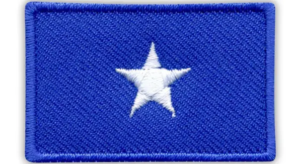 Naszywka z flagą Somalii: niebieskie tło z białym, pięcioramiennym gwiazdorem pośrodku.