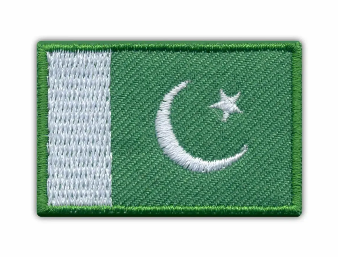 Naszywka z flagą Pakistanu. Zielone tło z białym półksiężycem i gwiazdą, oraz pionowym białym pasem po lewej stronie.