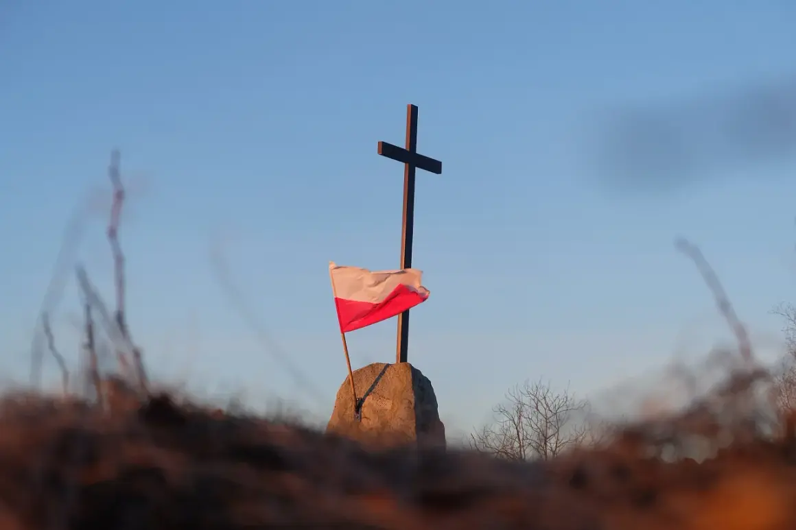 Na kamieniu, pod krzyżem, powiewa biało-czerwona flaga Polski.