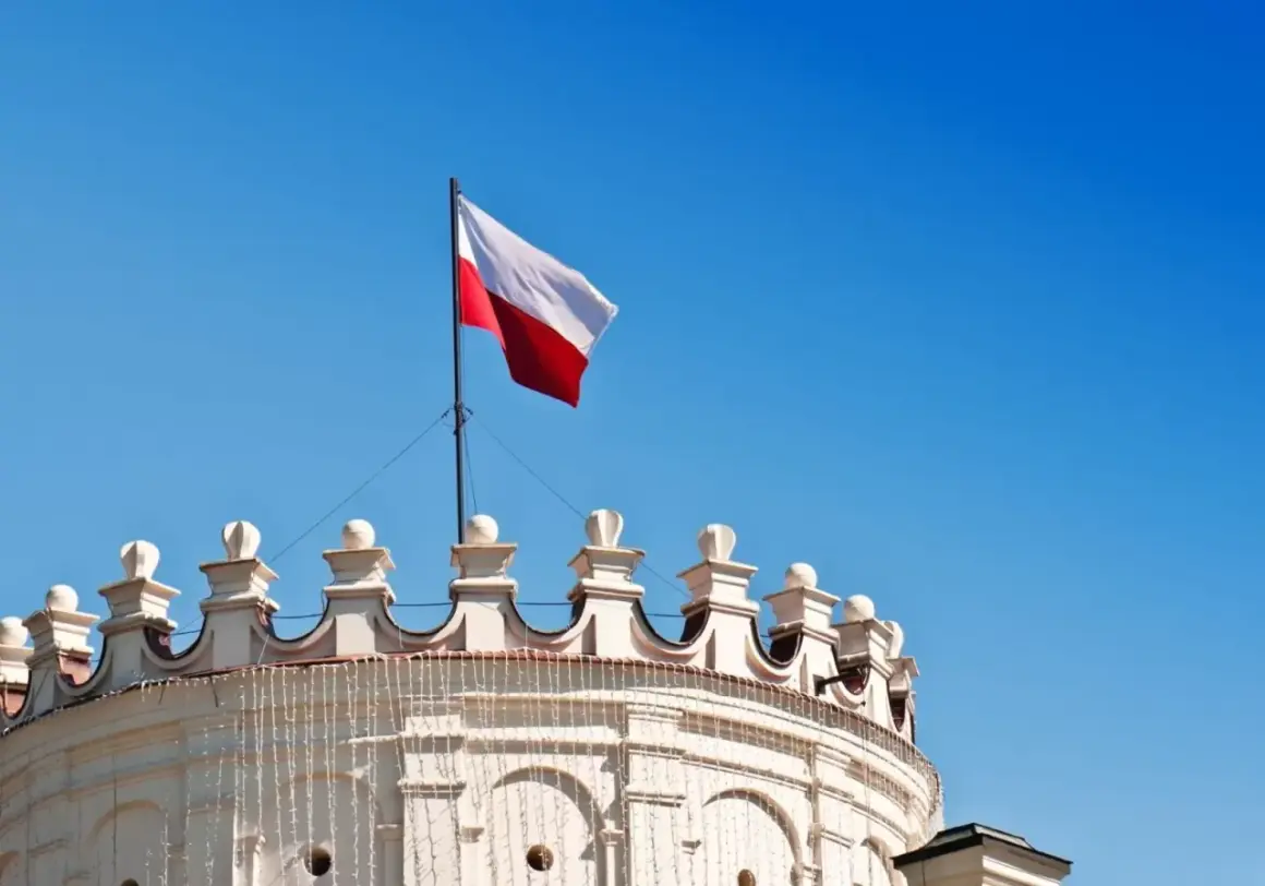Biało-czerwona flaga Polski powiewa na maszcie nad zabytkowym budynkiem. Wymiary flagi polski są standardowe, a jej kolory symbolizują dumę narodową.