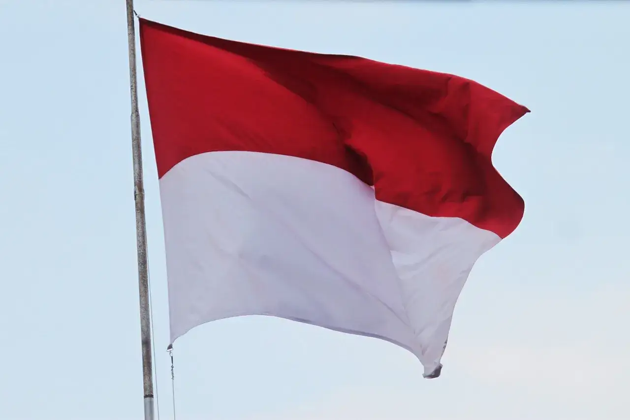 Flaga Indonezji, biało-czerwona, powiewa na maszcie. Tak wygląda flaga Indonezji.