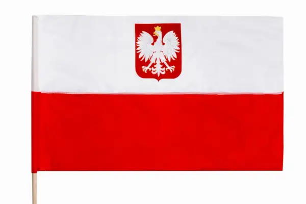 Flaga Polski z białym orłem w koronie na czerwonym tle, na drewnianym kiju.