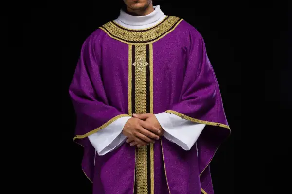 Szata liturgiczna w barwach papieskich, fioletowa z bogatymi złotymi zdobieniami, symbolizująca czas pokuty i refleksji.