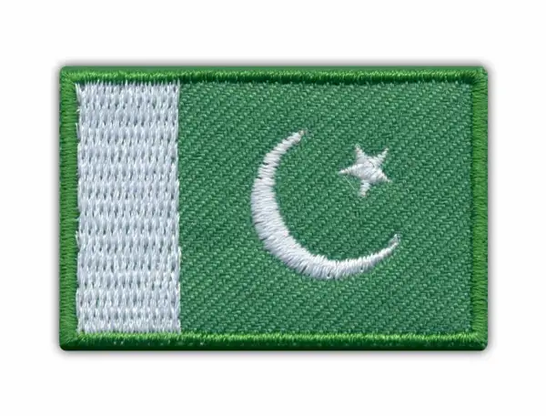 Naszywka z flagą Pakistanu. Zielone tło z białym półksiężycem i gwiazdą, oraz pionowym białym pasem po lewej stronie.