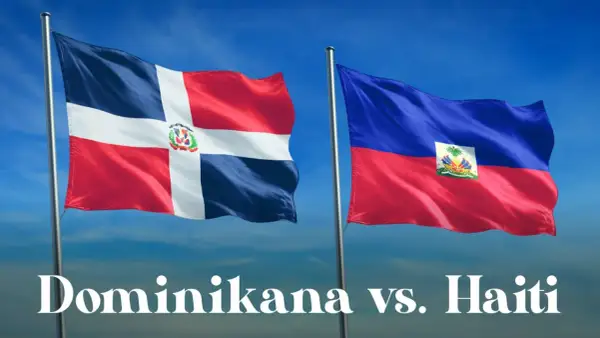 Dwie flagi powiewają na wietrze: dominikana flaga z białym krzyżem i herbem oraz flaga Haiti.
